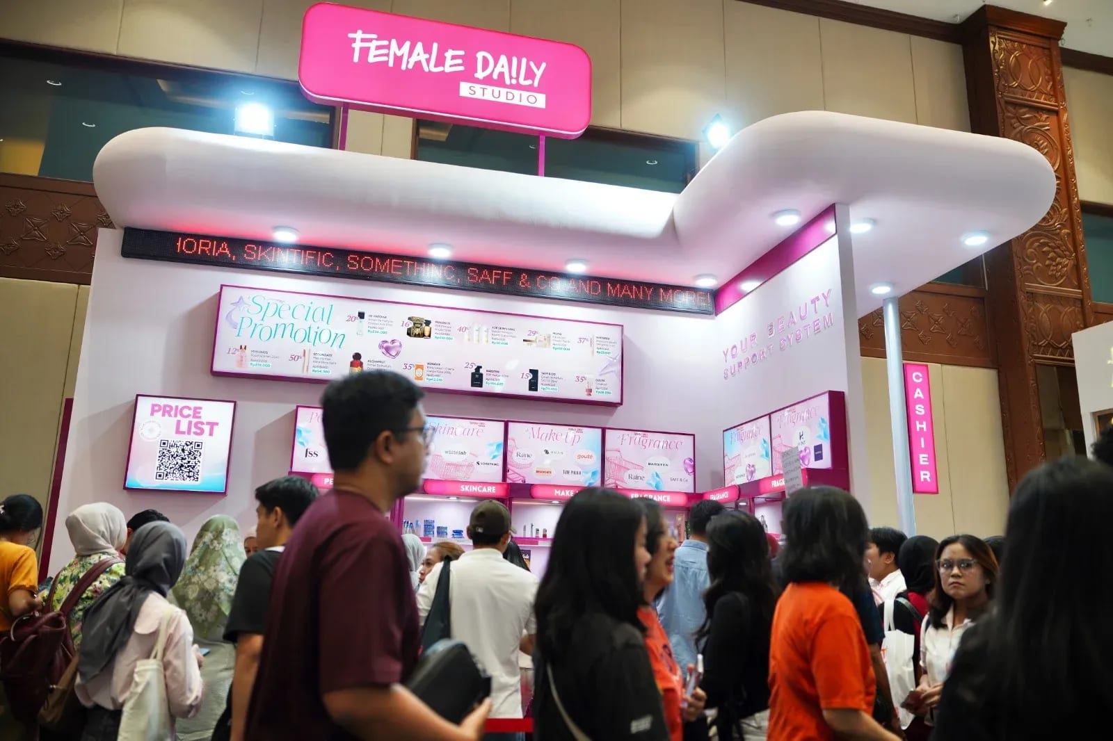Visitors queue at the pink-and-white Female Daily Studio booth, with skincare, make-up and fragrance shelves, at Jakarta x Beauty 2026