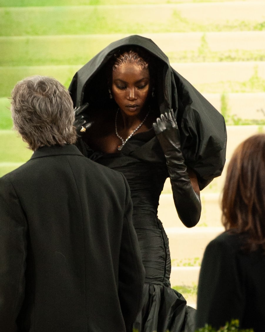 Anok Yai in a hooded black Balenciaga gown and long black gloves on the steps of the Metropolitan Museum of Art at the 2026 Met Gala