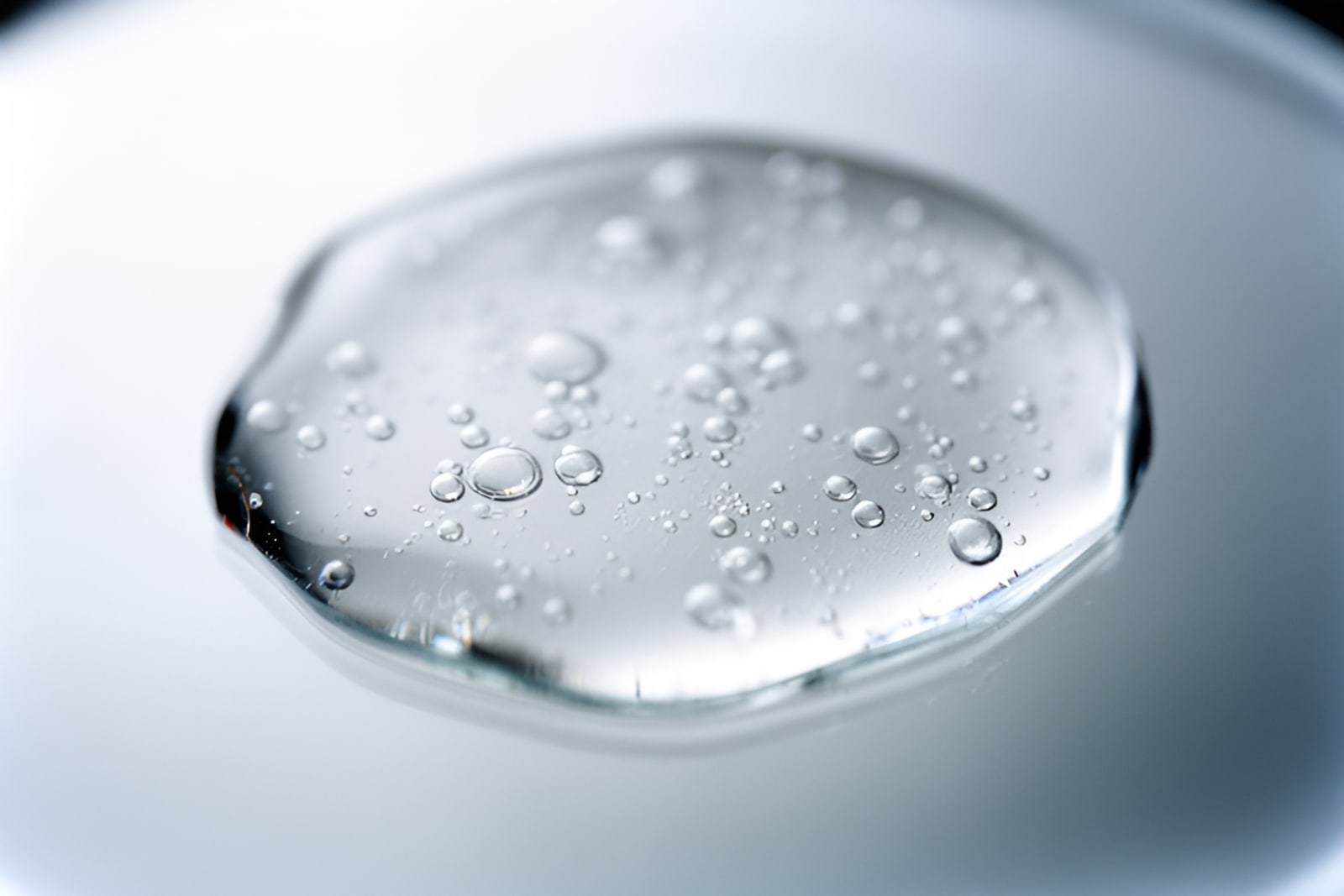 Macro of a clear, slightly milky serum spread on glass with tiny bubbles